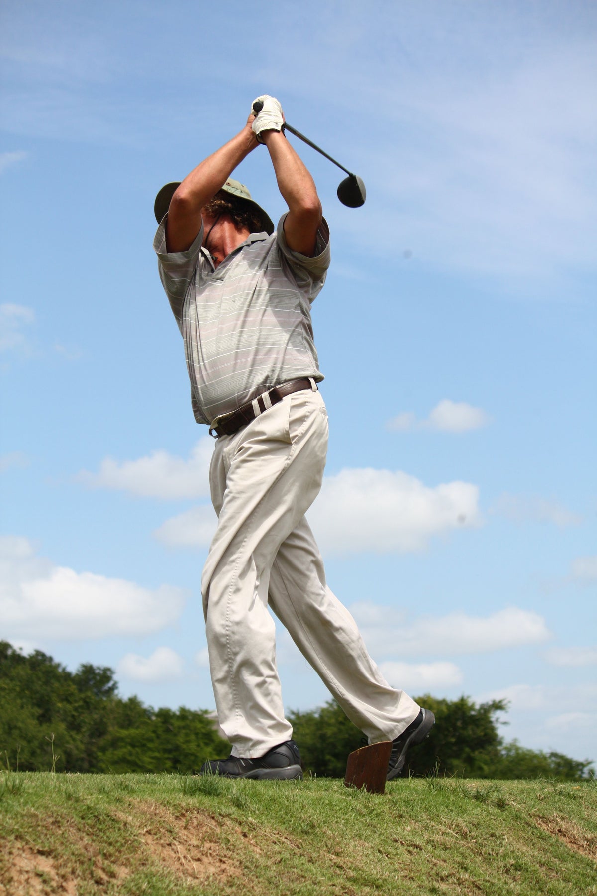 Golfer mid-swing demonstrating tempo training on the course